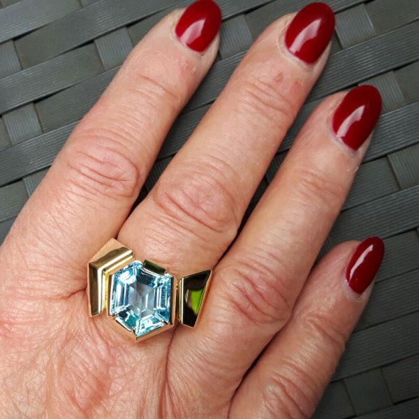 Ring met edeltopaas van boven en onder in facetten geslepen.